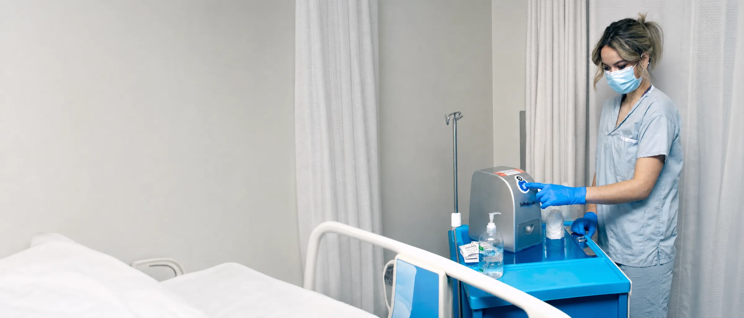 A nurse presses the button of a SafeCrush pill crusher on a medication cart