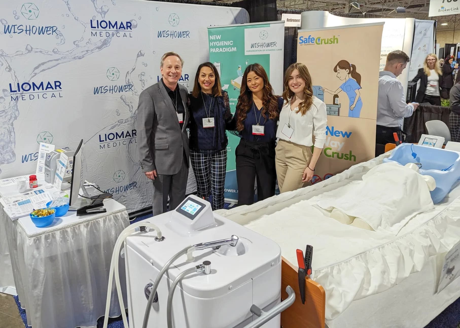 The LIOMAR Medical team at its Together We Care 2023 booth, beside the Wishower and the SafeCrush