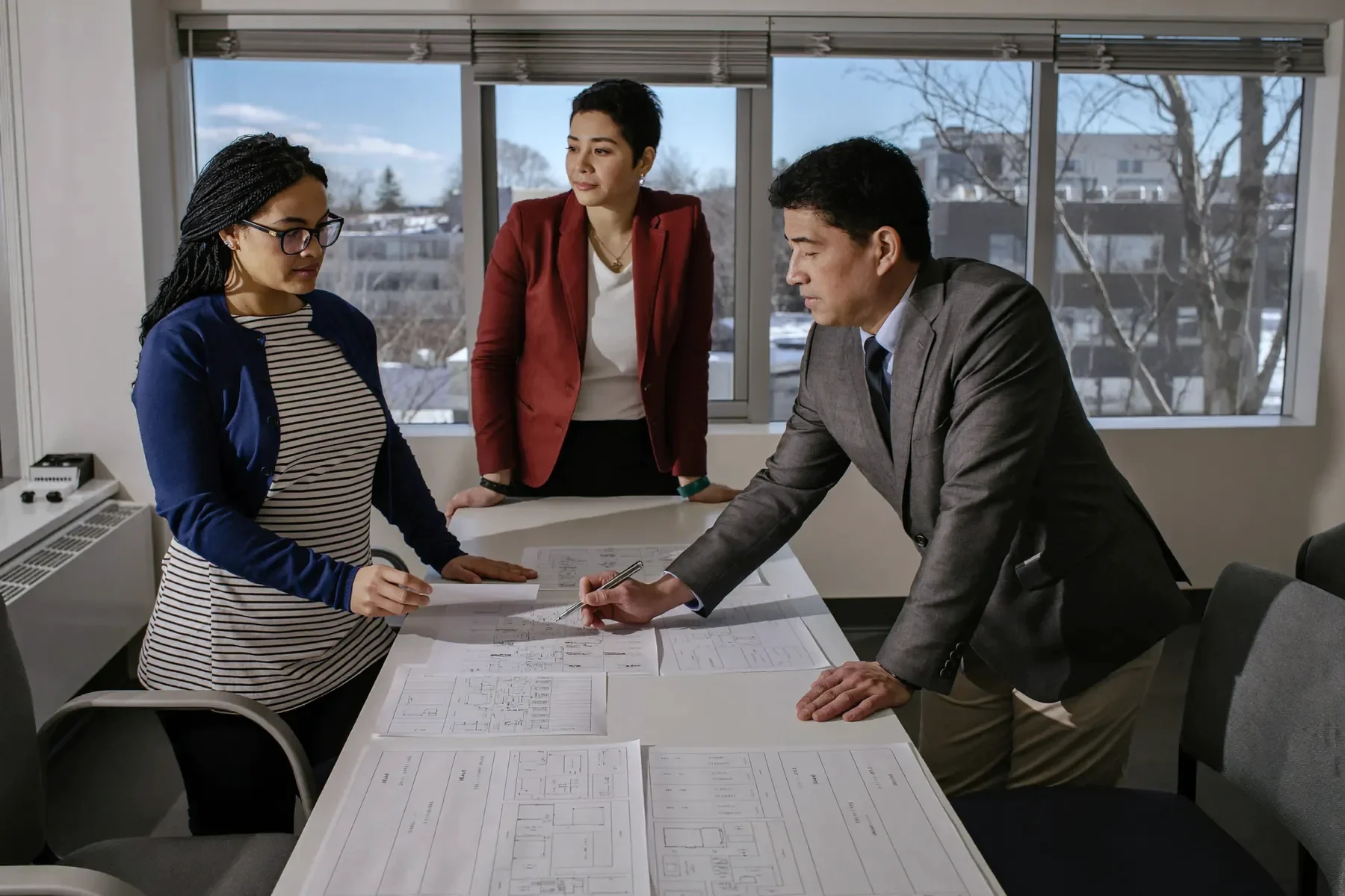 Three people discussing a distribution agreement around a table