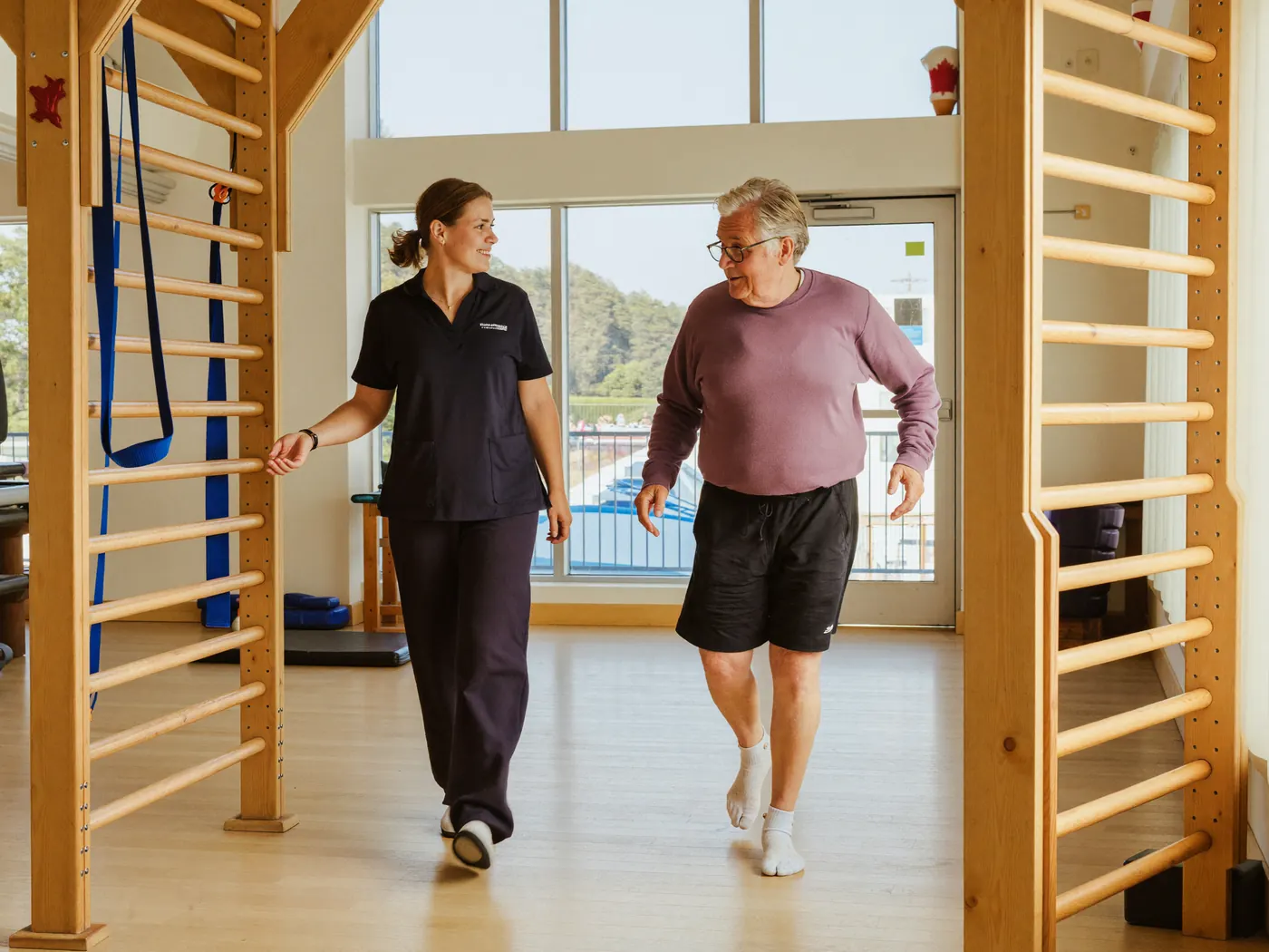 A caregiver walking beside a patient in a rehabilitation centre