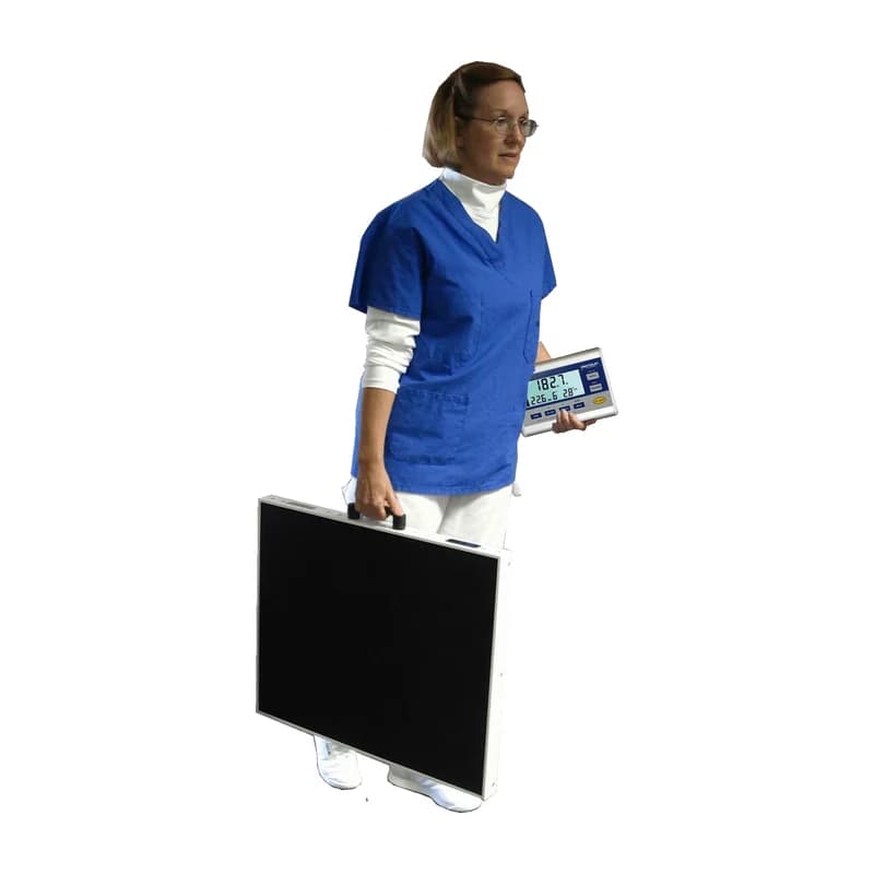 A caregiver carrying the Befour MX170 scale by its handle, console in hand