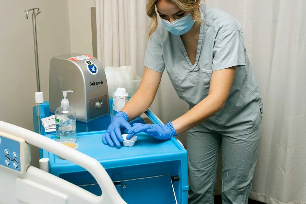 A nurse at a medication cart with a SafeCrush pill crusher