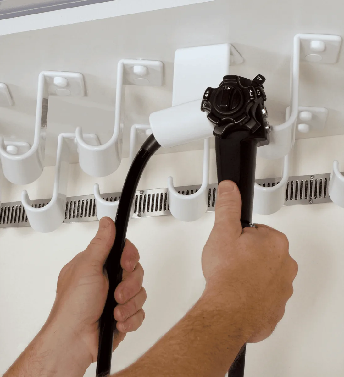 An endoscope being hung on a rotating hook in a TruAir cabinet