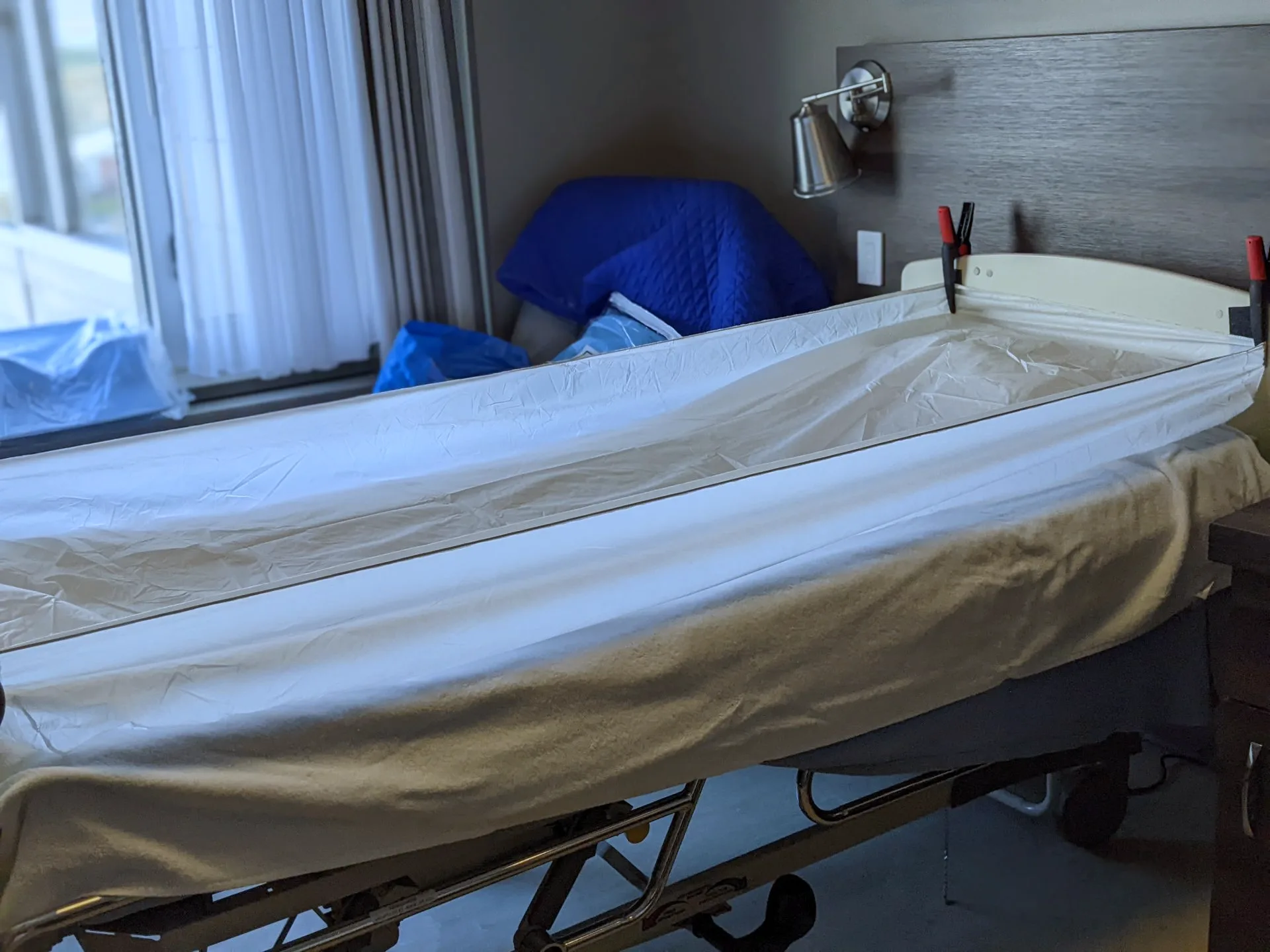 Un lit muni d’un couvre-lit imperméable Wishower posé sur la serviette format lit et retenu par des pinces