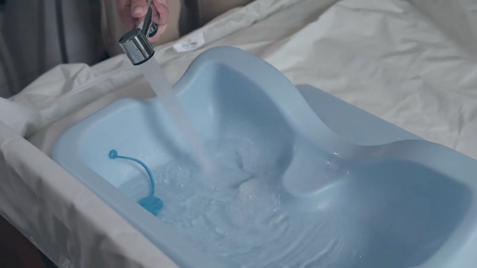 The Wishower shampoo basin filling with water on a bed
