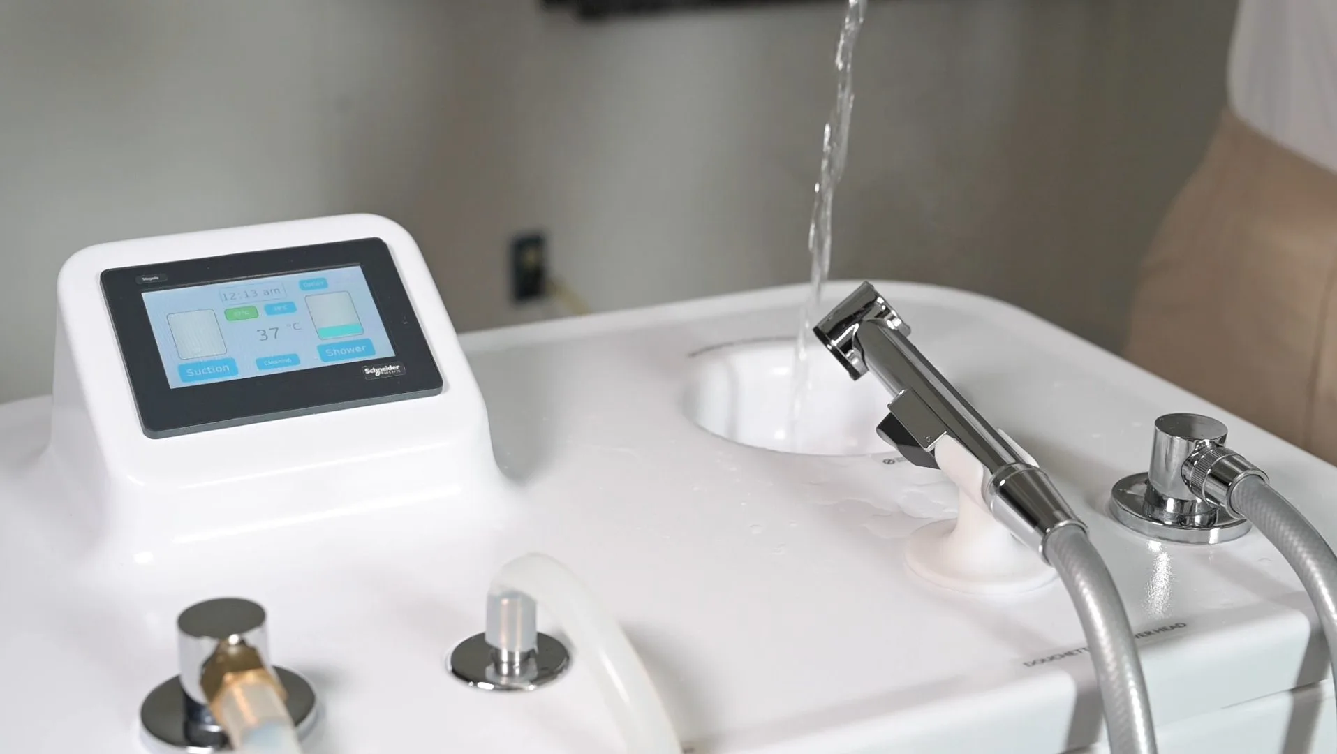 De l'eau tiède versée dans le réservoir d'eau propre du Wishower, à côté de l'écran tactile